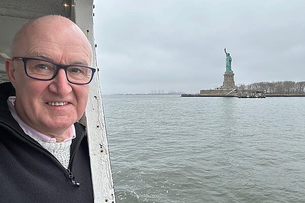 Andrew Kempston Parkes in New York near the statue of liberty